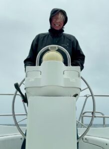 A. C. Burch at the helm of his boat, Nepenthe