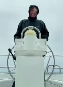 A. C. Burch at the helm of his boat, Nepenthe